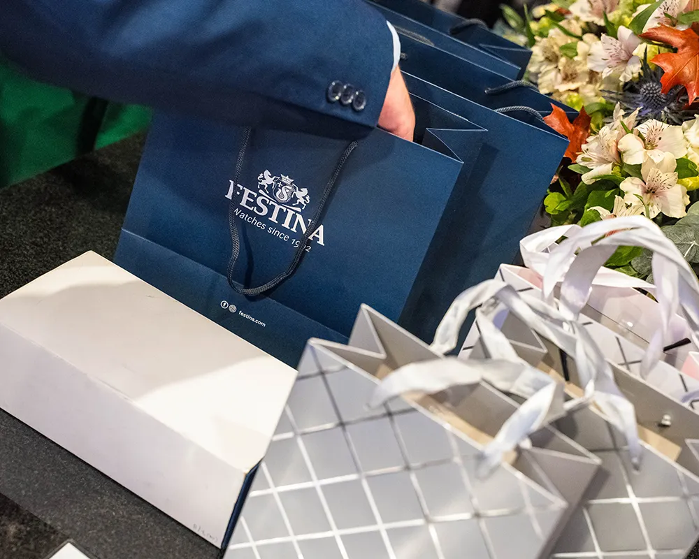Ajándéktasakok és virágok egy rendezvény fogadópultján